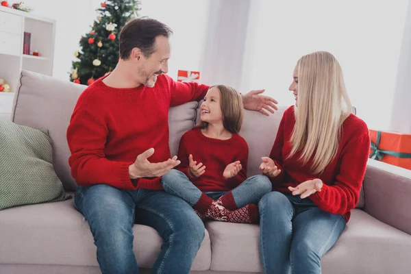 Портрет привлекательной веселой семейной жены, сидящей на диване, проводящей праздничные каникулы, общающейся с детьми дома в помещении — стоковое фото