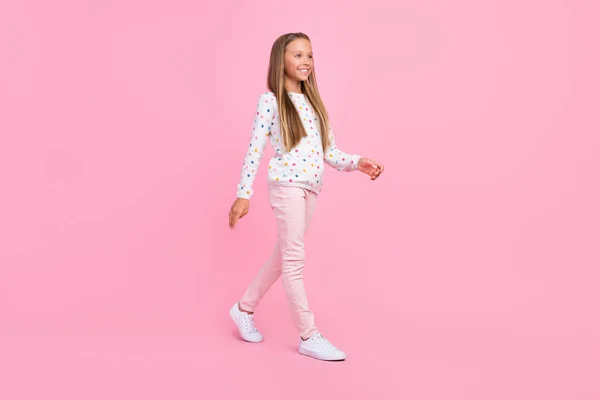 Profil zdjęcie pozytywny miły beztroski mała pani spacer nosić kropkowane spodnie obuwie odizolowany różowy kolor tło — Zdjęcie stockowe