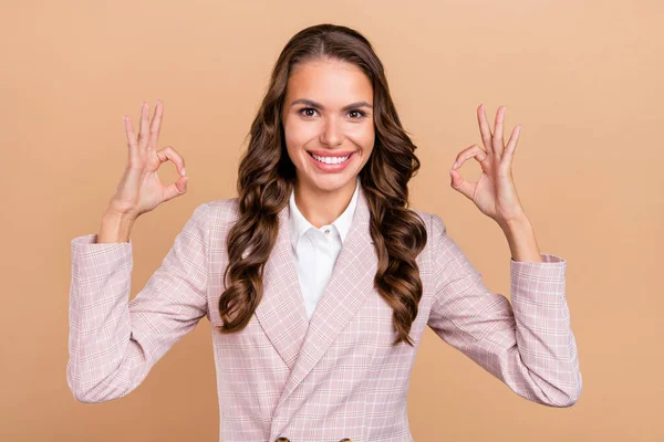 Retrato de positivo menina bonita dois braços dedos fazer okey símbolo dente sorriso isolado no fundo cor bege — Fotografia de Stock