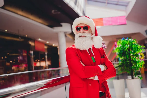 Zdjęcie modny pewny siebie przystojny Mikołaj nosić ciemne ramiona okularów skrzyżowane uśmiechnięty butik sklep — Zdjęcie stockowe