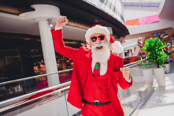 Портрет привлекательного веселого Санты, радующегося празднику Рождества в торговом центре в помещении — стоковое фото