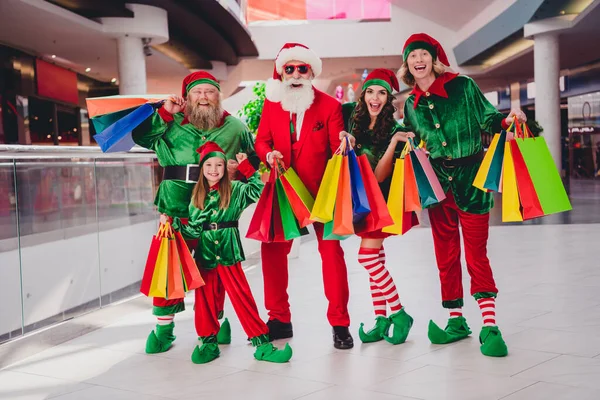 Pleine longueur vue de la taille du corps de joyeux amis de groupe elfes achetant Décembre cadeaux de fête au centre commercial à l'intérieur — Photo