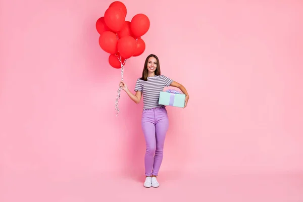 魅力的な甘い若い女性の写真は、ストライプの服を着て笑顔保持赤い風船プレゼントボックス孤立ピンク色の背景 — ストック写真
