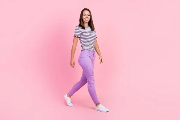 Photo of adorable shiny young lady wear striped outfit smiling walking isolated pink color background — Stock Photo, Image