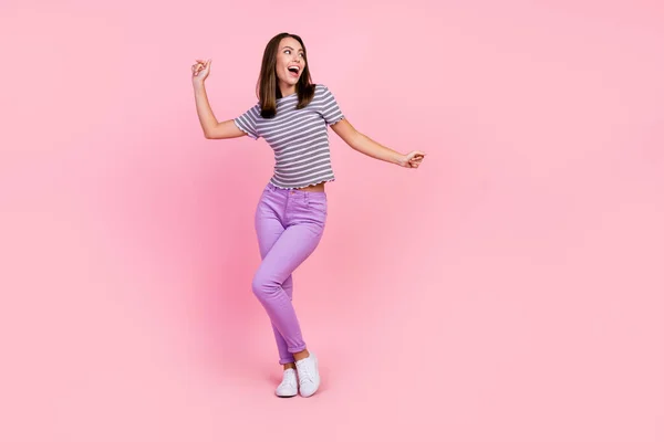 Foto de linda encantadora joven vestida con ropa de rayas bailando sonriente aislado color rosa fondo — Foto de Stock