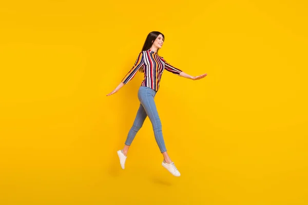 Повнометражний профіль фотографія молодої жінки щасливий позитивний стрибок посмішки йде крок ізольовано на жовтому кольоровому фоні — стокове фото