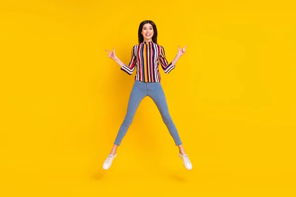 Фотографія повного тіла молодої жінки щаслива позитивна посмішка підстрибує точкові пальці порожній простір прямий спосіб реклами ізольовані на жовтому кольорі — стокове фото