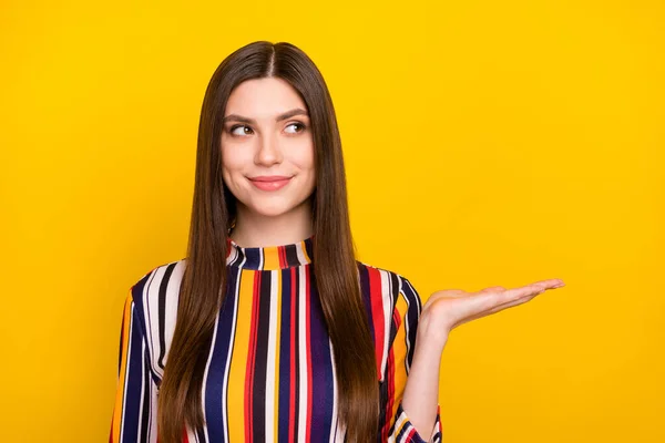 Foto av ung attraktiv kvinna glad positiv leende hålla hand produkt promo erbjudande annons isolerad över gul färg bakgrund — Stockfoto
