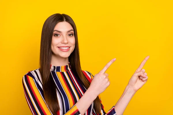 Foto de jovem atraente menina feliz sorriso positivo apontar dedos espaço vazio direto seguir anúncio isolado sobre fundo de cor amarela — Fotografia de Stock