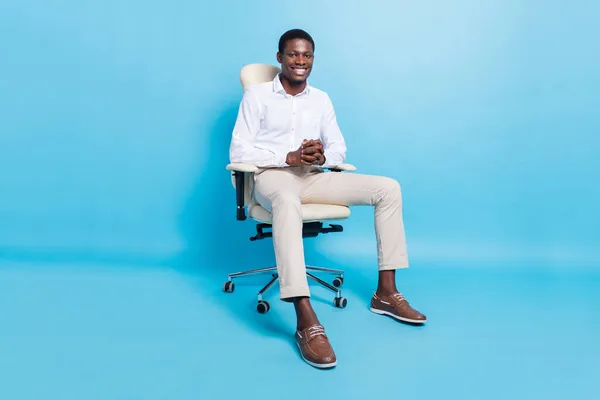 自信を持って正の暗い肌の男性の写真は、白いシャツを着て笑顔座っ椅子隔離された青の背景 — ストック写真