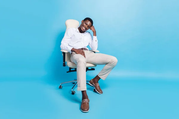 かなり思慮深い黒い肌の男の写真正式なシャツ座って椅子笑顔隔離された青の色の背景 — ストック写真