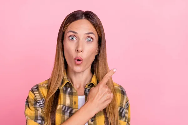 Фото враженого шокованого веселого позитивного молодої жінки вказують пальцем на порожній простір продаж новин ізольовано на рожевому кольоровому фоні — стокове фото