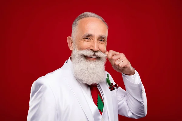 Photo positive vieil homme joyeux toucher moustache porter arbre cravate noël humeur isolé sur fond de couleur rouge — Photo