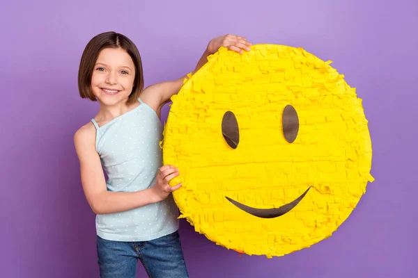 Foto van positieve charmante kleine meisje goed humeur houd handen emoji glimlach geïsoleerd op paarse kleur achtergrond — Stockfoto