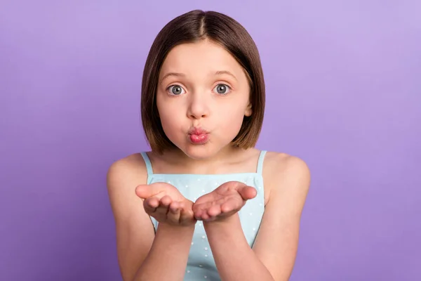 매력적 인 어린 소녀의 사진 공중 키스를 보내는 밝은 손을 보라색 배경에 고립된 쾌활 한 아가씨 — 스톡 사진