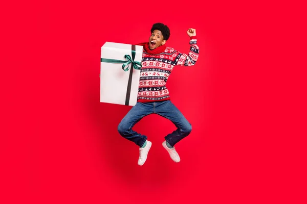 Full size fotografie mladého afro chlap šťastný pozitivní úsměv jumper dárek box oslava izolované přes červené barvy pozadí — Stock fotografie