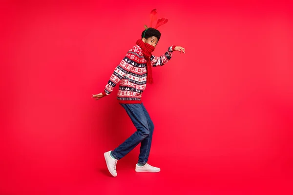Foto de perfil de longitud completa de millennial morena chico danza desgaste bufanda de vacaciones suéter jeans zapatos aislados sobre fondo rojo — Foto de Stock
