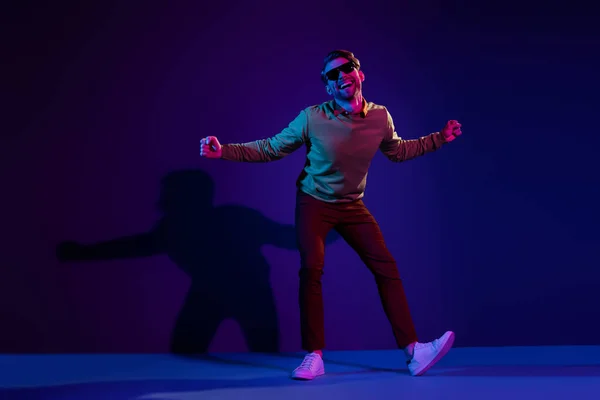 Foto de corpo inteiro de encantador jovem feliz homem engraçado dança clubber usar vidro solar isolado no fundo de néon — Fotografia de Stock