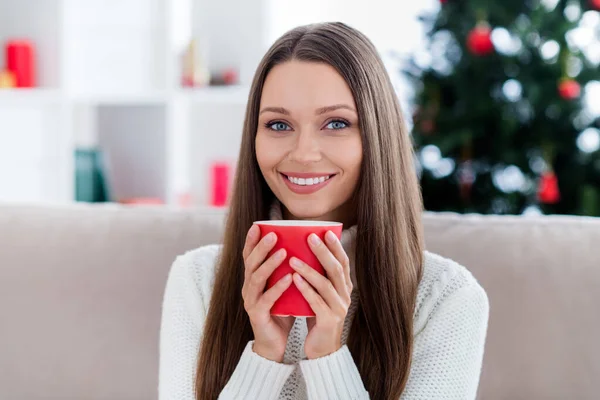 Foto av söt charmig ung dam bära vit pullover leende dricka välsmakande äggtoddy inomhus hus hem rum — Stockfoto