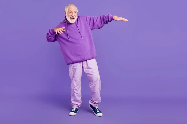Ganzkörpergröße Ansicht der attraktiven fröhlichen grauhaarigen Mann Narren tanzen isoliert über helle violett lila Farbe Hintergrund — Stockfoto