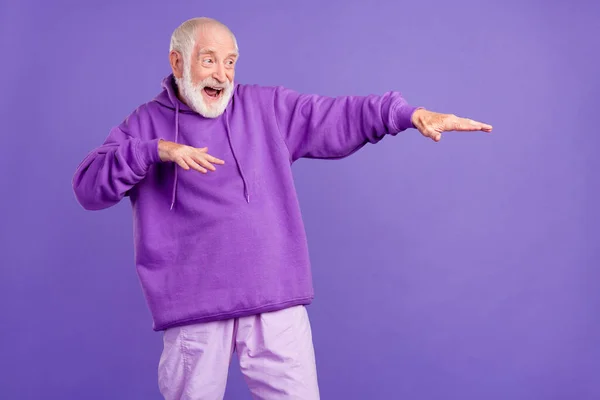 Portrait of attractive cheerful grey-haired man having fun moving clubbing dancing isolated over bright violet purple color background — Stock Photo, Image
