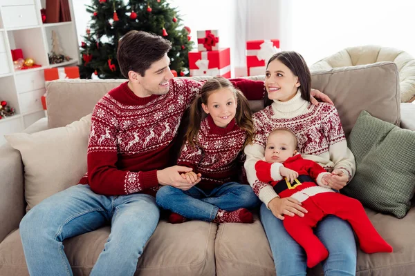 Foto von niedlichen süßen Paar zwei Kinder gekleidet Neujahr Pullover lächelnd sitzend Couch kuscheln drinnen Haus Home Room — Stockfoto