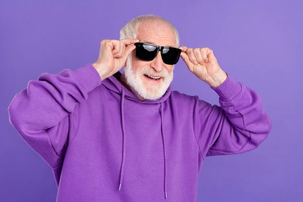 Portrait of attractive cheerful grey-haired man touching specs good mood isolated over bright violet purple color background — Stock Photo, Image