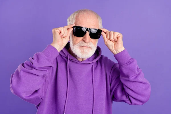 Portrait of attractive content serious grey-haired man touching specs modern look isolated over bright violet purple color background — Stock Photo, Image