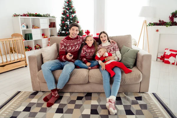 Zdjęcie uroczego męża żony dzieci nosić swetry Boże Narodzenie siedzi sofa przytulanie oglądając film w domu domu — Zdjęcie stockowe