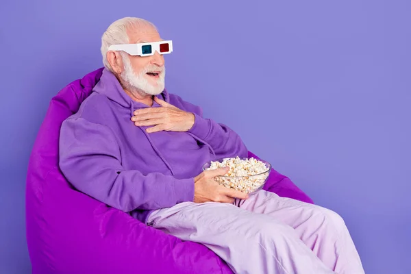 Profile side photo of senior man have fun weekend pop corn laughter joke watch movie isolated over violet color background — Stock Photo, Image