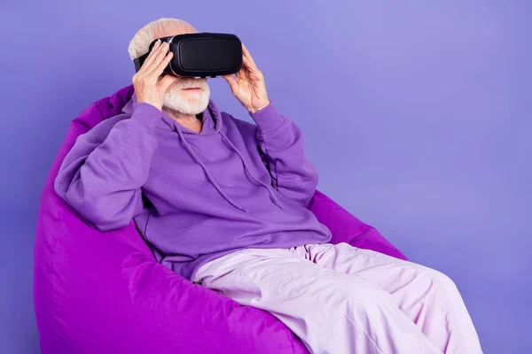 Profile side photo of aged man wear virtual reality glasses fantasy future game player isolated over violet color background