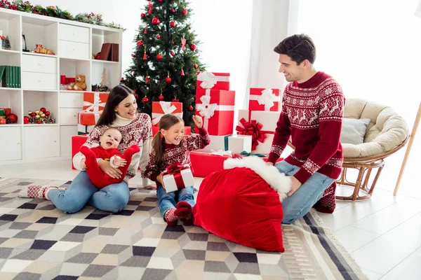 Foto van leuke grappige echtgenoot vrouw twee kinderen dragen kerst truien zitten onder de boom wachtende cadeautjes glimlachen binnen kamer huis — Stockfoto