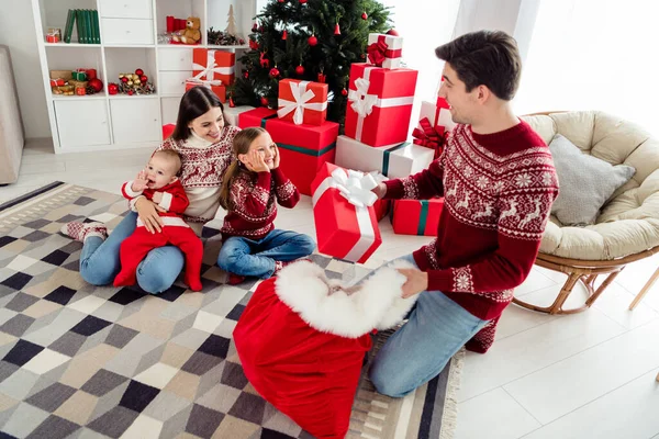 Foto van opgewonden zoet paar twee kinderen gekleed nieuwjaar pullovers glimlachen het krijgen van geschenken binnen huis home room — Stockfoto