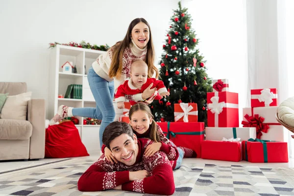 Foto van jonge vrolijke familie blij positieve glimlach genieten van de winter vakantie cadeau doos decoratie binnen — Stockfoto