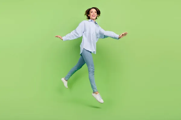 明るい正の素敵な幸せな女性のフル長さの写真上にジャンプします歩く空のスペース隔離された緑の色の背景 — ストック写真