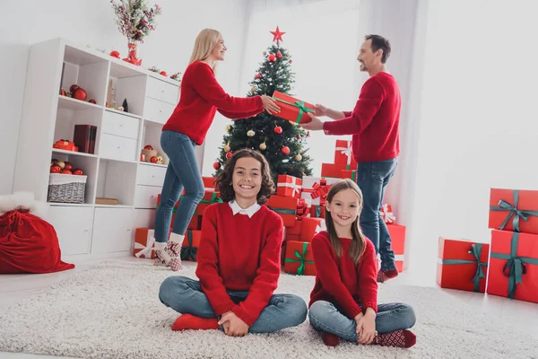 Volledige lichaamsomvang uitzicht van mooie knappe vrolijke familie delen geschenkdozen December wintertijd thuis huis binnen — Stockfoto