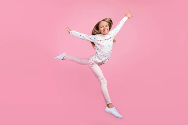 Foto av inspirerad liten dam hoppa njuta av flygning slitage prickig pyjamas byxor skor isolerad rosa färg bakgrund — Stockfoto
