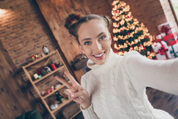 Foto de menina feliz sorriso positivo mostrar paz fresco v-sinal atirar selfie decoração luzes feriado inverno sempre verde árvore dentro de casa — Fotografia de Stock