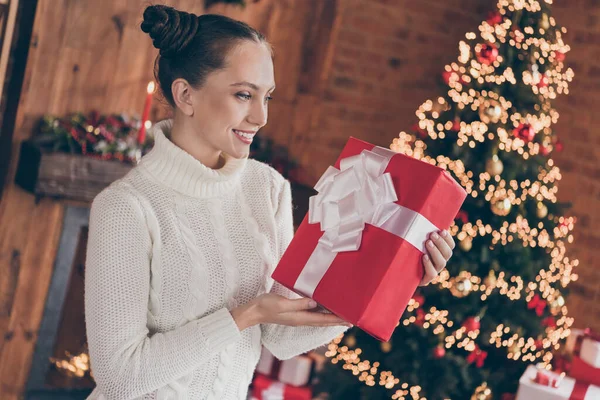 Προφίλ πλευρά φωτογραφία του νεαρού χαρούμενο κορίτσι χαρούμενο θετικό χαμόγελο κρατήστε πατημένο κουτί χριστουγεννιάτικο φωτισμό παράδοση σε εσωτερικούς χώρους — Φωτογραφία Αρχείου
