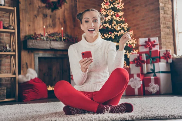 Foto de tamaño completo de niña feliz sonrisa positiva sentarse piso uso smartphone Navidad ambiente decoración en el interior —  Fotos de Stock