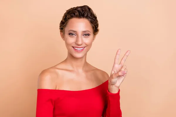 Foto de alegre legal jovem mulher feliz fazer v-sign Olá saudações isoladas no fundo cor bege pastel — Fotografia de Stock