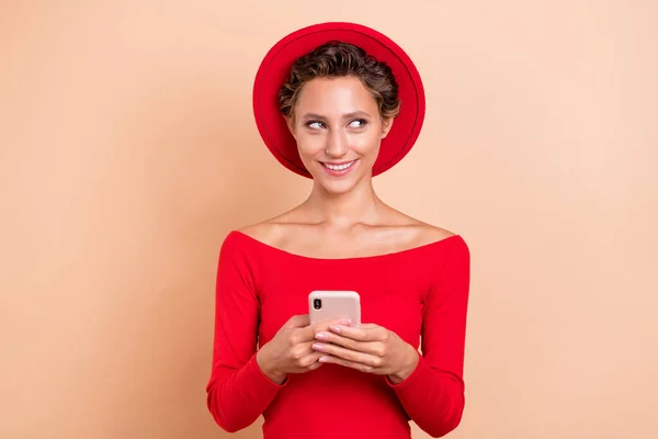 Fénykép álmodozó boldog fiatal nő tartsa telefon néz üres tér hiszem post elszigetelt bézs színű háttér — Stock Fotó