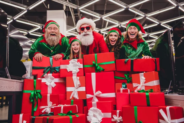 Ritratto di attraente stupito allegro gruppo elfi acquisto pile Gift Box divertirsi vigilia dell'avvento tradizione al mercato negozio al coperto — Foto Stock