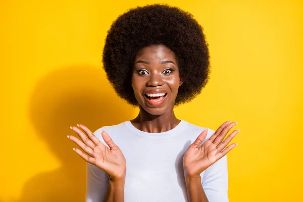 Retrato de la morena linda impresionada pelo corto señora brazos hasta usar jersey blanco aislado sobre fondo de color amarillo vivo — Foto de Stock