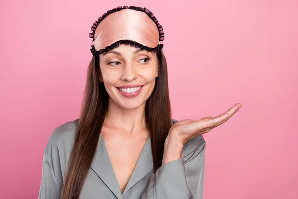 Ritratto di attraente allegra donna dai capelli lunghi in possesso di spazio copia sulla soluzione di palma isolato su sfondo rosa pastello — Foto Stock