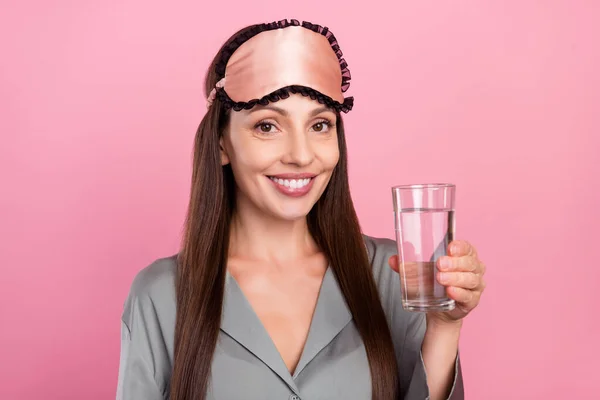 Фото зрілої жінки щаслива позитивна посмішка пийте освіжаючість у скляній воді та ізольовані на фоні рожевого кольору — стокове фото