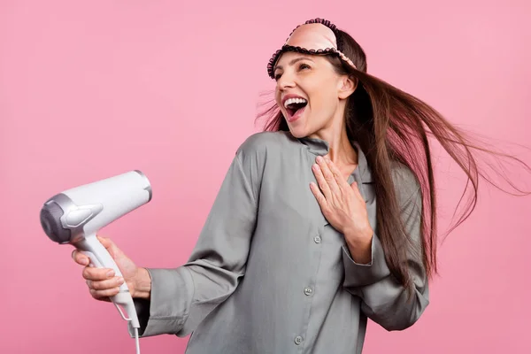 Foto di donna matura felice sorriso positivo asciugacapelli cura dei capelli notturno isolato su sfondo di colore rosa — Foto Stock