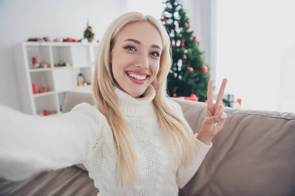 Foto de la joven atractiva mujer feliz sonrisa positiva mostrar paz fresco v-signo hacer selfie vacaciones de Navidad en el interior — Foto de Stock