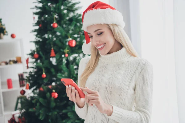 Foto di dolce affascinante giovane donna vestita maglione bianco digitando gadget moderno sorridente casa interna stanza — Foto Stock