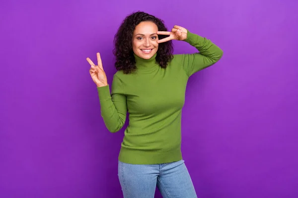 面白いです可愛いですアフロ女性の写真を着て緑のタートルネックショーvサインカバー目笑顔孤立紫色の背景 — ストック写真